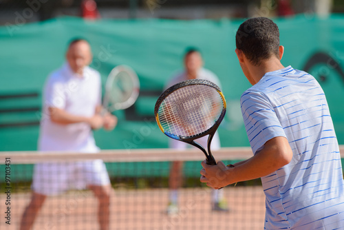 Men playing doubles game of tennis © auremar