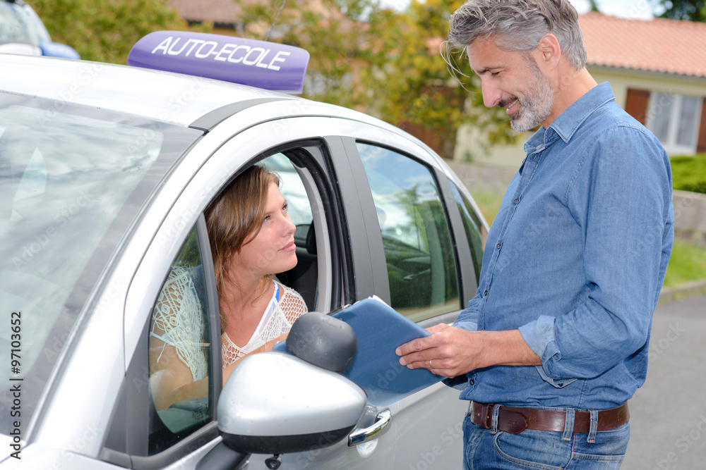 Learner driver looking out of car window talking to instructor Learner driver looking out of car window talking to instructor