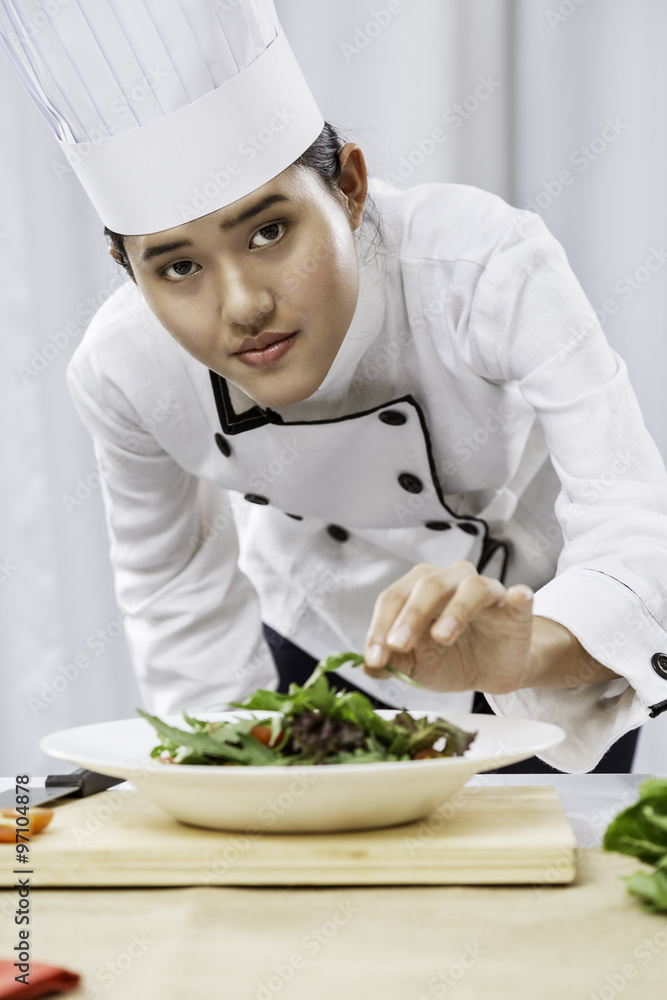 portrait of female chef patiently placing salad on a plate
portrait of female chef patiently placing salad on a plate
