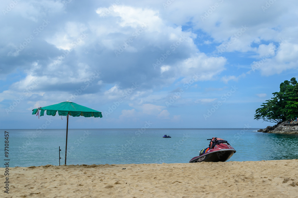 Jet ski on the beach and green umbrella in Phuket Thailand