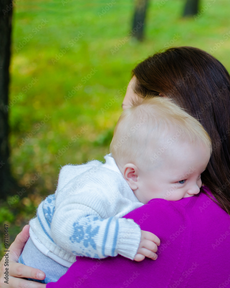 Mother hugs her baby in the park. Outdoors. Mother hugs her baby in the park. Outdoors.