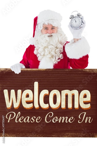 Composite image of santa claus holding alarm clock and sign