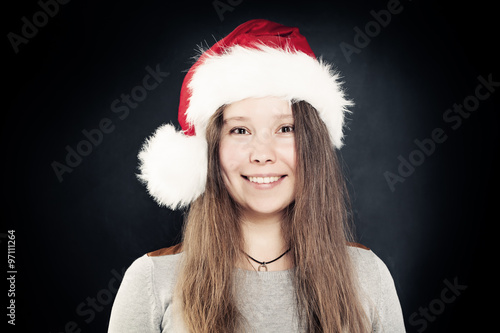 Smiling Woman in Santa Hat on Dark Background. Real People. Chri