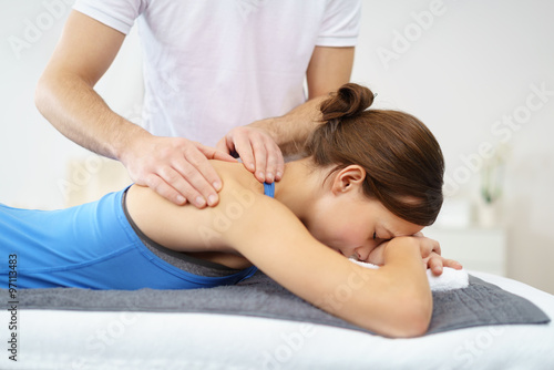 physiotherapeut untersucht eine patientin mit schmerzen an der schulter