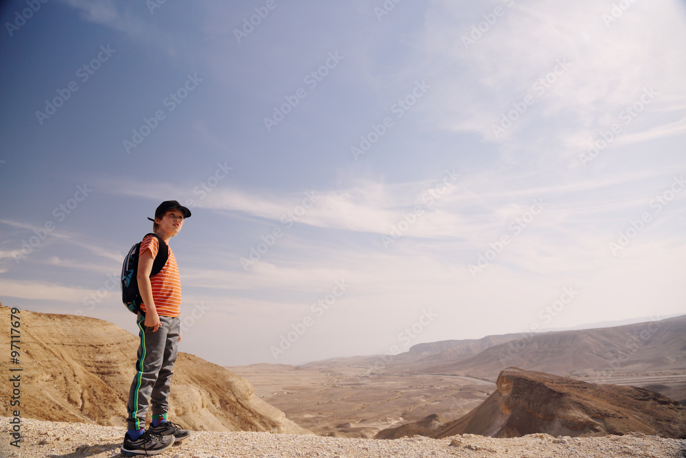 Fototapeta premium Cute 8 years old boy hiking in the desert