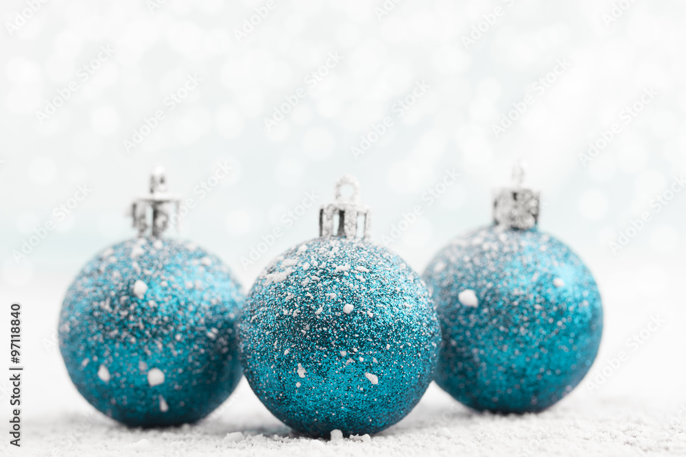 Christmas ball in the snow on blurred light background. A holiday card. Traditional Christmas decorations. Christmas ball in the snow on blurred light background. A holiday card. Traditional Christmas decorations.