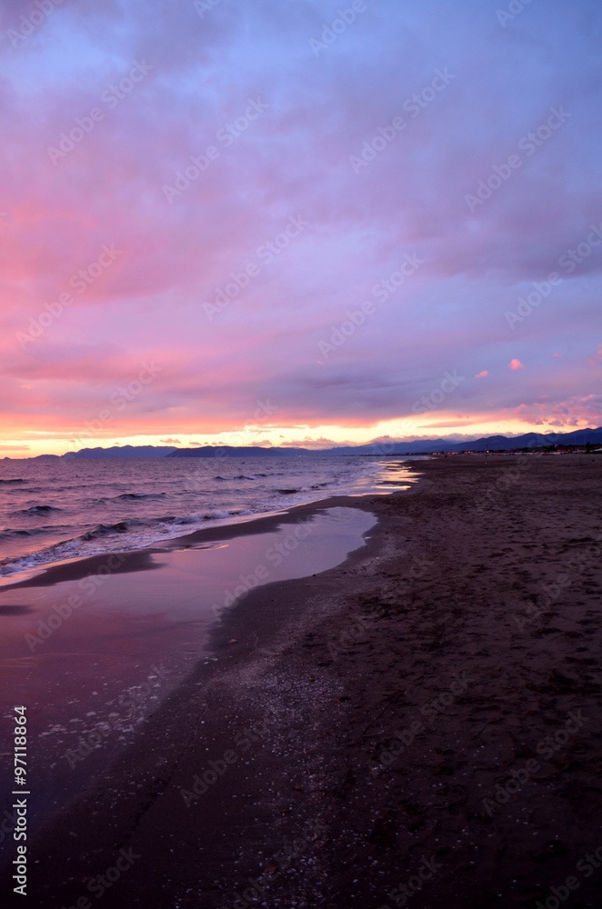 Sea waves during a colorful sunset over a beautiful and romantic beach
