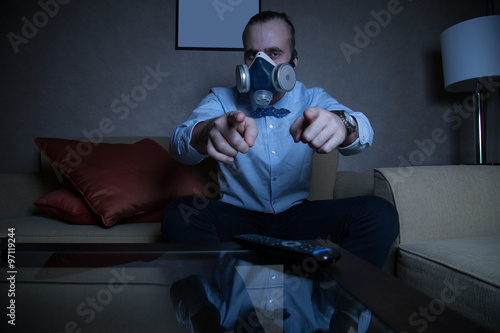 Man in respirator watching TV