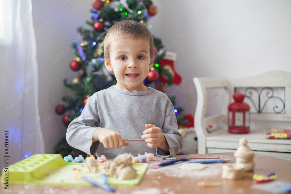 Cute little boy, playing with modeling dough, molding figures at home on Christmas Cute little boy, playing with modeling dough, molding figures at home on Christmas