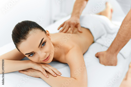Spa Woman. Beauty Treatment. Beautiful Young Healthy Caucasian girl relaxing with hand Massage Procedure In The Spa Salon. Masseur Massaging her Back. Body Care. Skin Care, Wellness, Wellbeing.