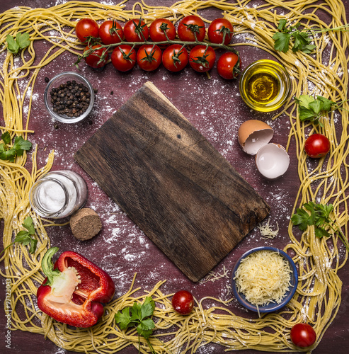 raw pasta, lined frame around ingredients border ,place for text on wooden rustic background top view