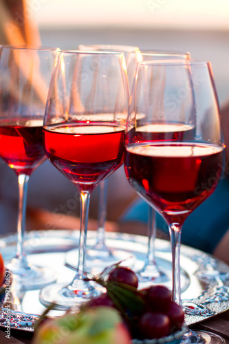Glasses of the red wine on the sunset beach