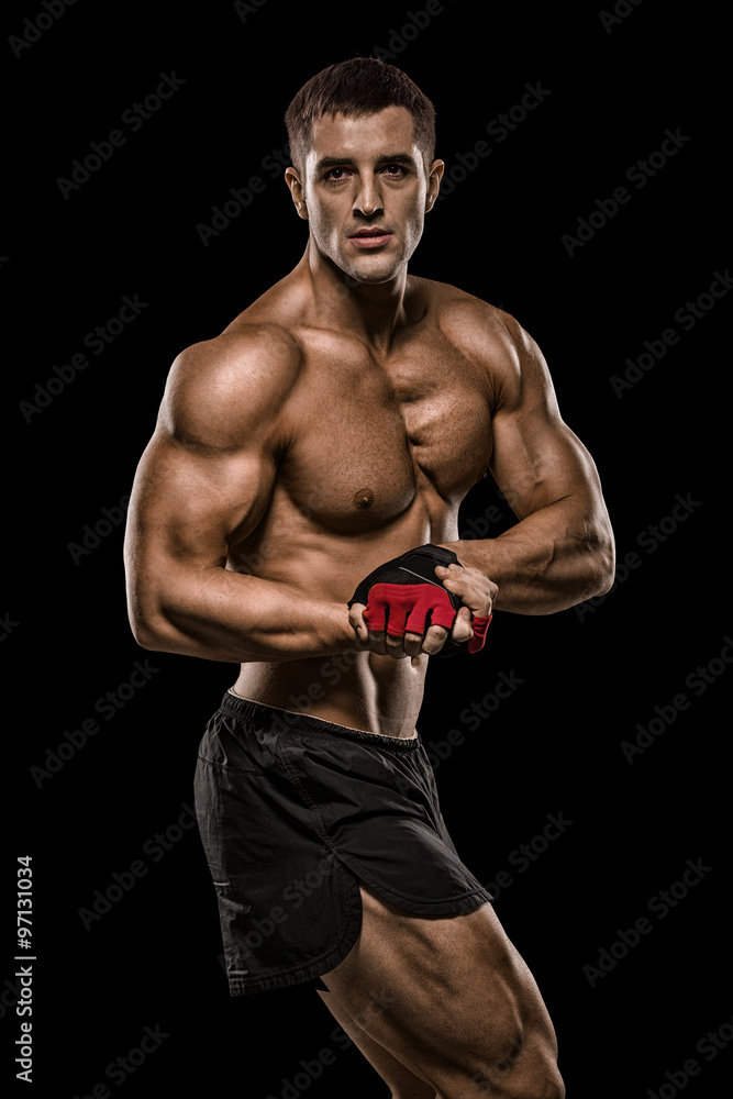 Shirtless bodybuilder holding dumbell and showing his muscular a