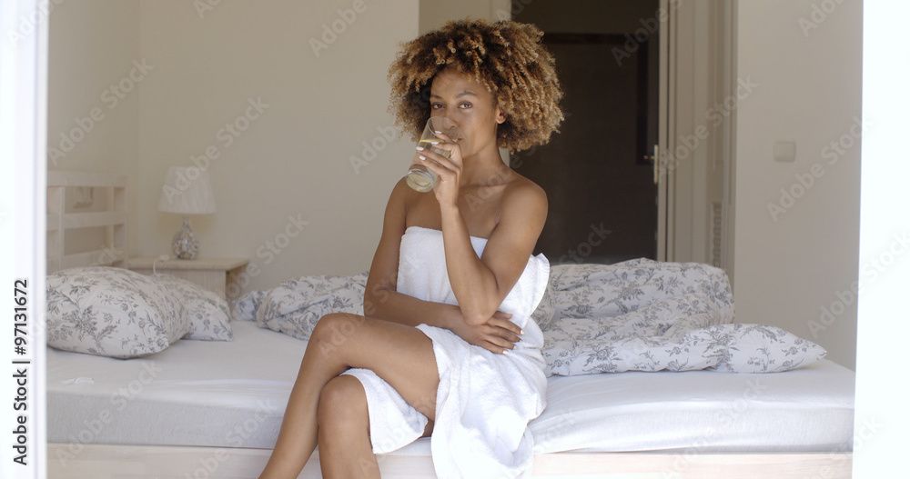 Naklejka premium Girl Drinking Fresh Water On The Bed