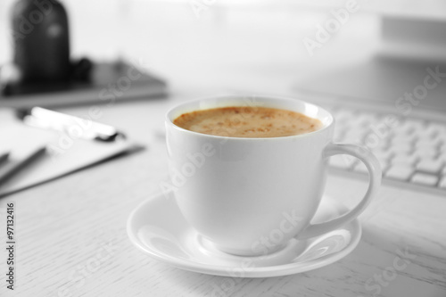 Cup of coffee on workplace background