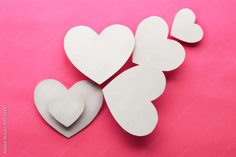 White paper hearts on pink background White paper hearts on pink background