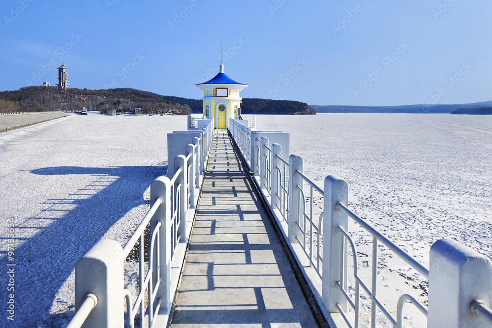 Idyllic scenery with a pier in a frozen lake