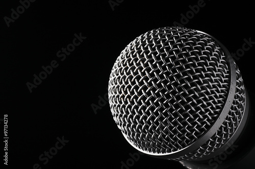 Silver microphone on a black background. © kamiwro