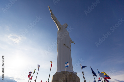 Cristo del Rey statue of Cali with world flags and blue sky, Col