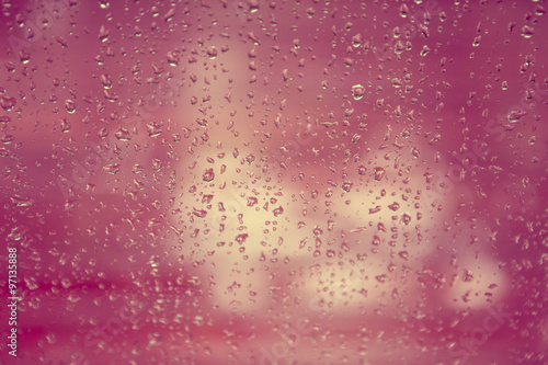 rain drop on window glass with blur tree background, vintage col