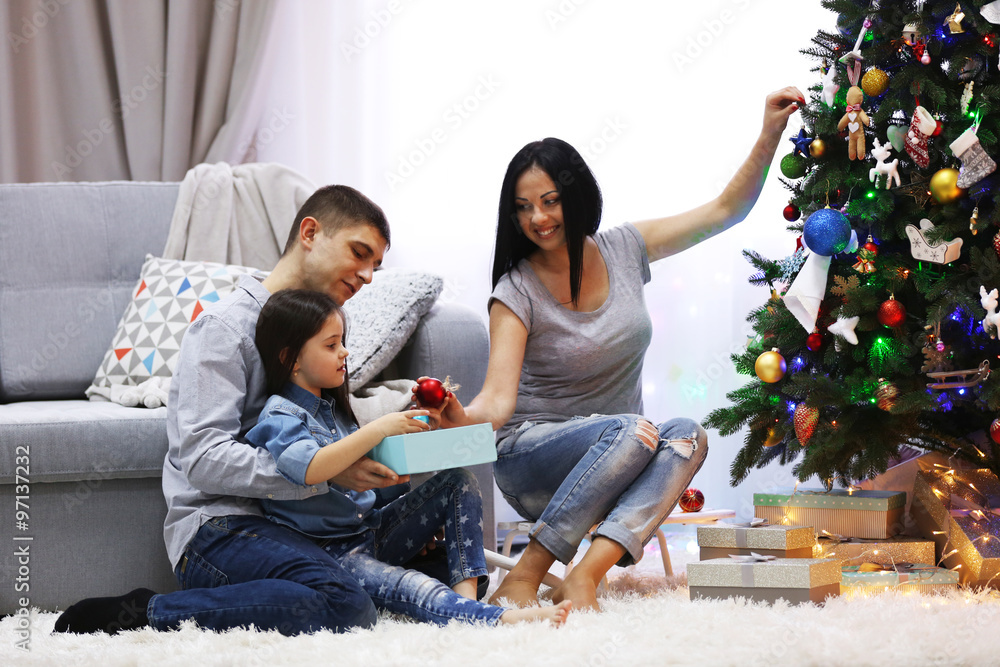 Happy family with gifts in the decorated Christmas room Happy family with gifts in the decorated Christmas room