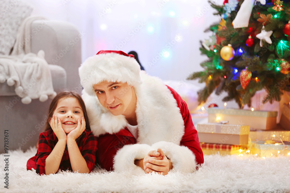 Happy father and daughter on the floor in the decorated Christmas room Happy father and daughter on the floor in the decorated Christmas room