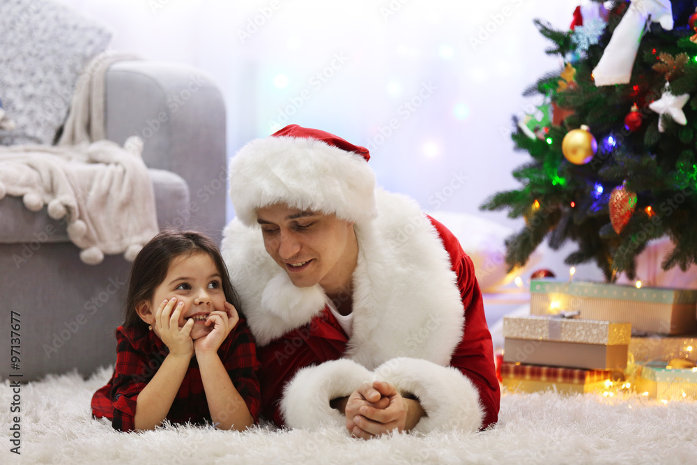Happy father and daughter on the floor in the decorated Christmas room Happy father and daughter on the floor in the decorated Christmas room