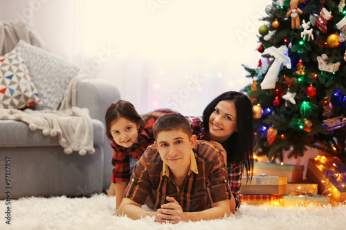 Happy family on the floor in the decorated Christmas room