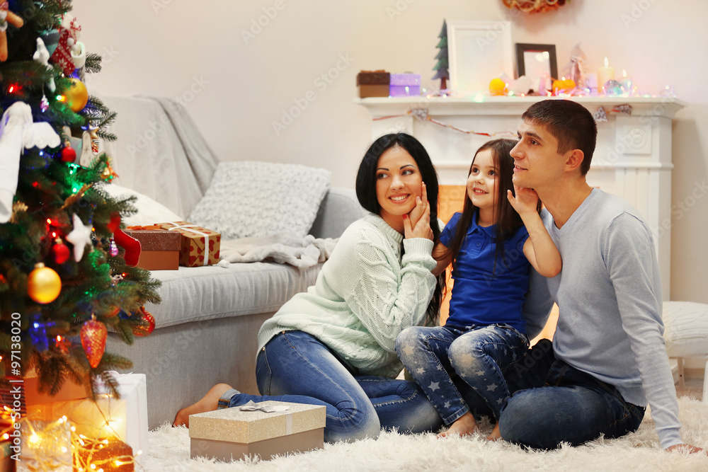 Happy family on the floor with gifts in the decorated Christmas room Happy family on the floor with gifts in the decorated Christmas room