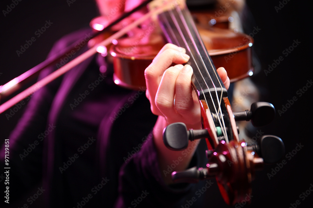 Woman plays violin on black background, close up