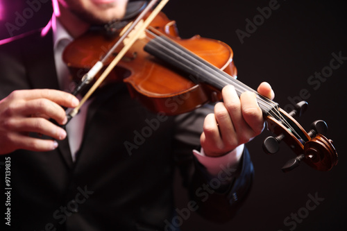 Violinist's performance on black background, close up