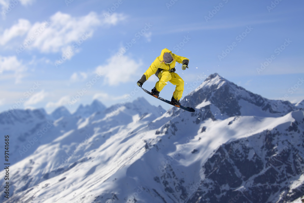 Flying snowboarder on mountains. Extreme sport.