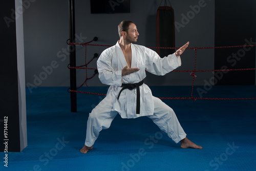 Man In White Kimono And Black Belt Training Karate