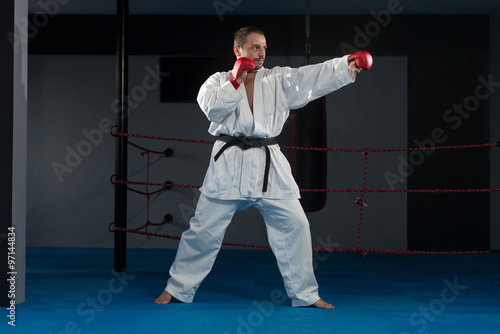 Man In White Kimono And Black Belt Training Karate