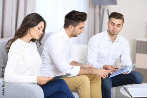 Estate agent presenting new project to happy couple, on light background