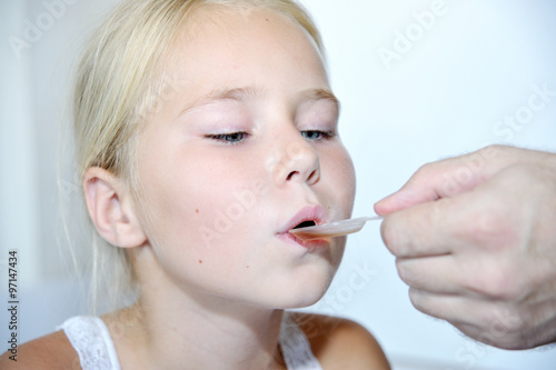 Wallpaper Mural Little girl taking medicine with spoon Torontodigital.ca