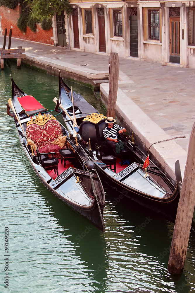 Gondoliere che riposa nella sua gondola a Venezia in un rio tranquillo