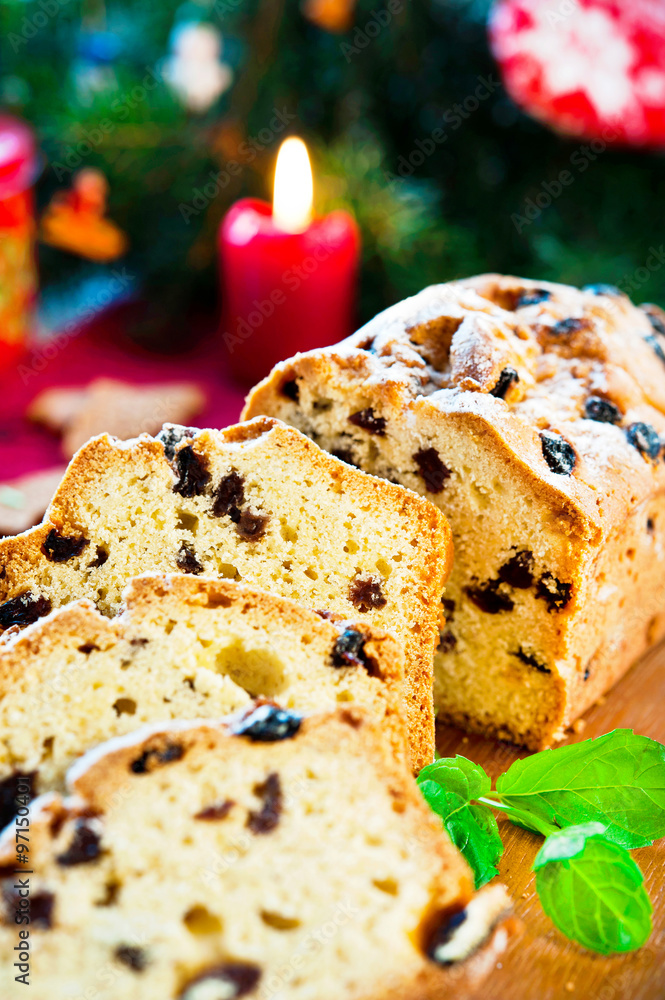 Festive sliced fruitcake with raisins and mint on christmas back Festive sliced fruitcake with raisins and mint on christmas back