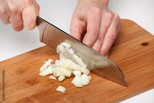 Cutting the vegetables with a kitchen knife on the board