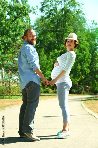 Happy moments in waiting baby's birth - man and woman walking in the park