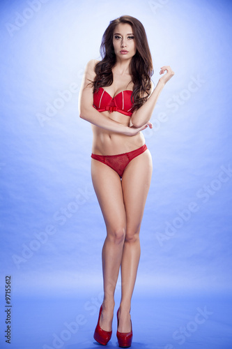 Young slim sexy woman in lingerie on blue background