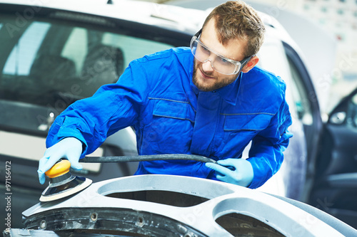 auto mechanic worker polishing bumper car photo