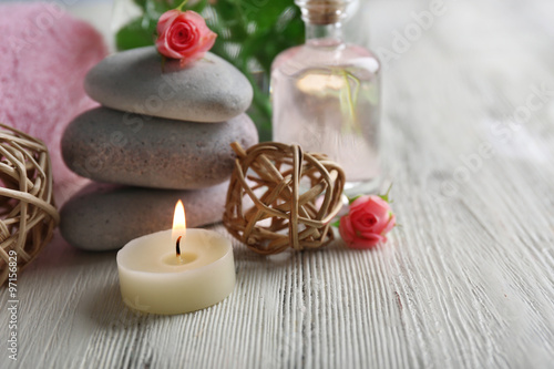 Composition of flowers  candles and stones on white wooden background  in spa salon