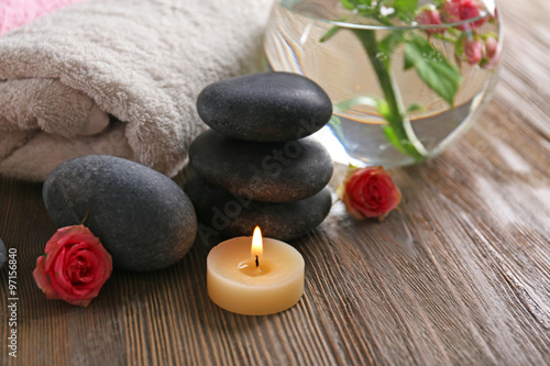 Spa composition of candles  flowers and stones on brown wooden background