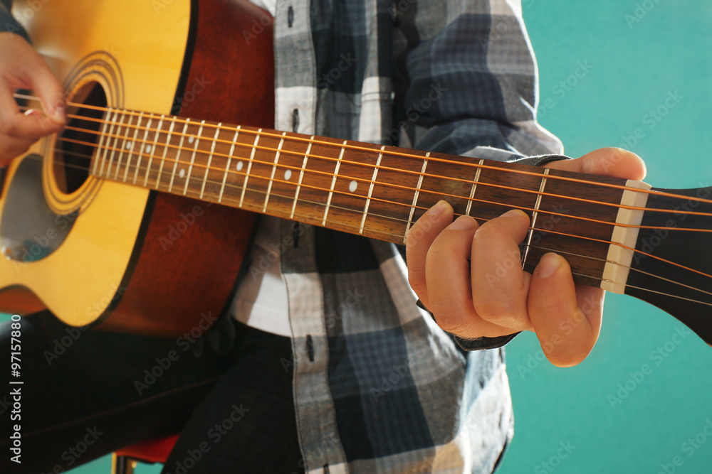 Musician plays guitar on blue background, close up Musician plays guitar on blue background, close up