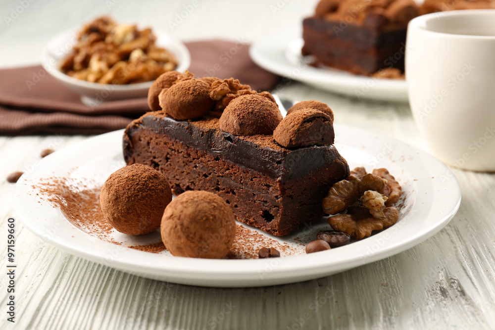 Chocolate balls and a piece of cake with walnut on the table, close-up Chocolate balls and a piece of cake with walnut on the table, close-up
