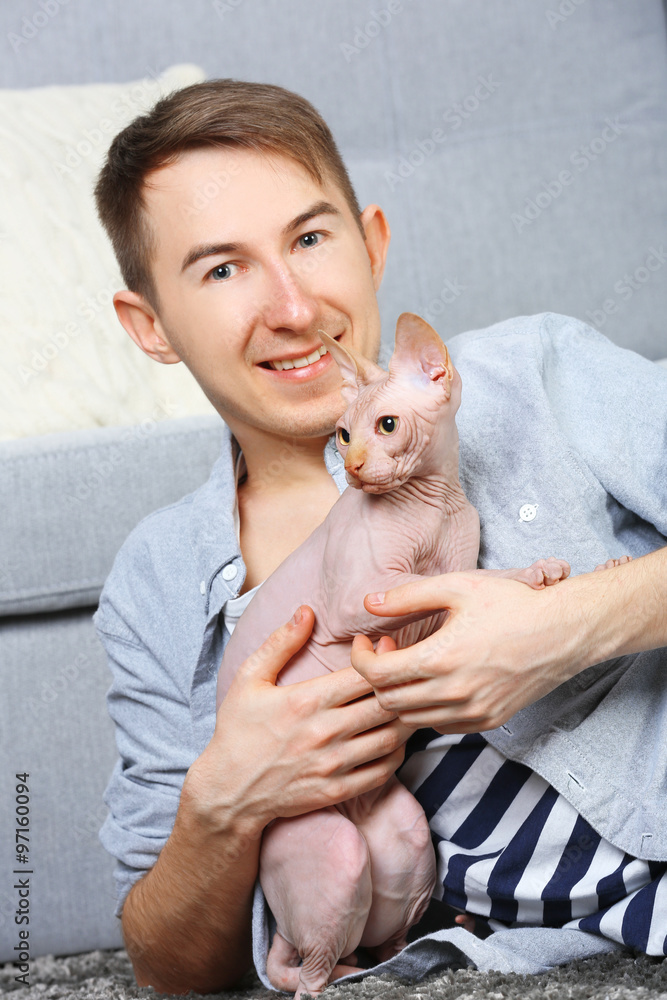 Young handsome man lies with cat on floor at home Young handsome man lies with cat on floor at home