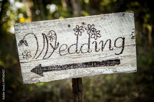 Rustic wedding arrow sign on a shovel.