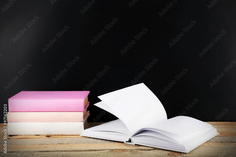 Fototapeta premium Books on a table on blackboard background