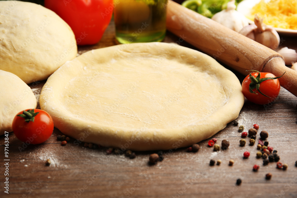 Dough basis and ingredients for pizza, on the table Dough basis and ingredients for pizza, on the table
